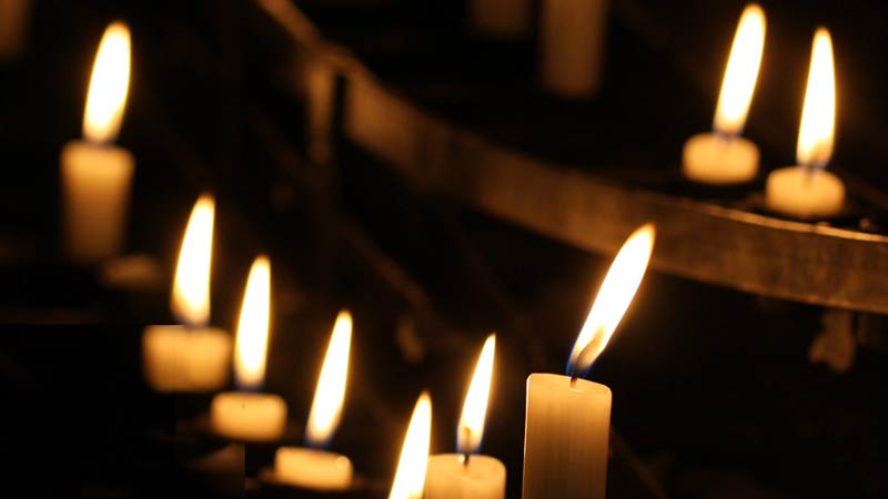 A row of lit candles in a church
