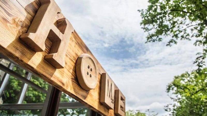 The wooden Home signage, including a large button for the 'O' and a Scrabble tile for the 'M'