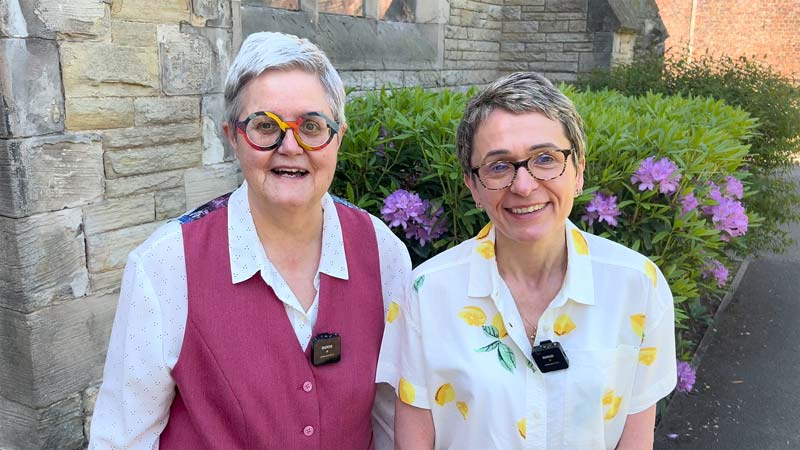 Gill and June stand smiling outside Emmanuel church