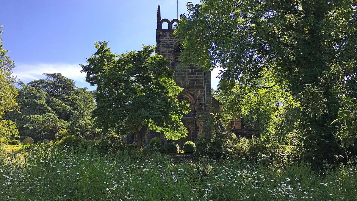View looking up at St James church from the wildflower meadow